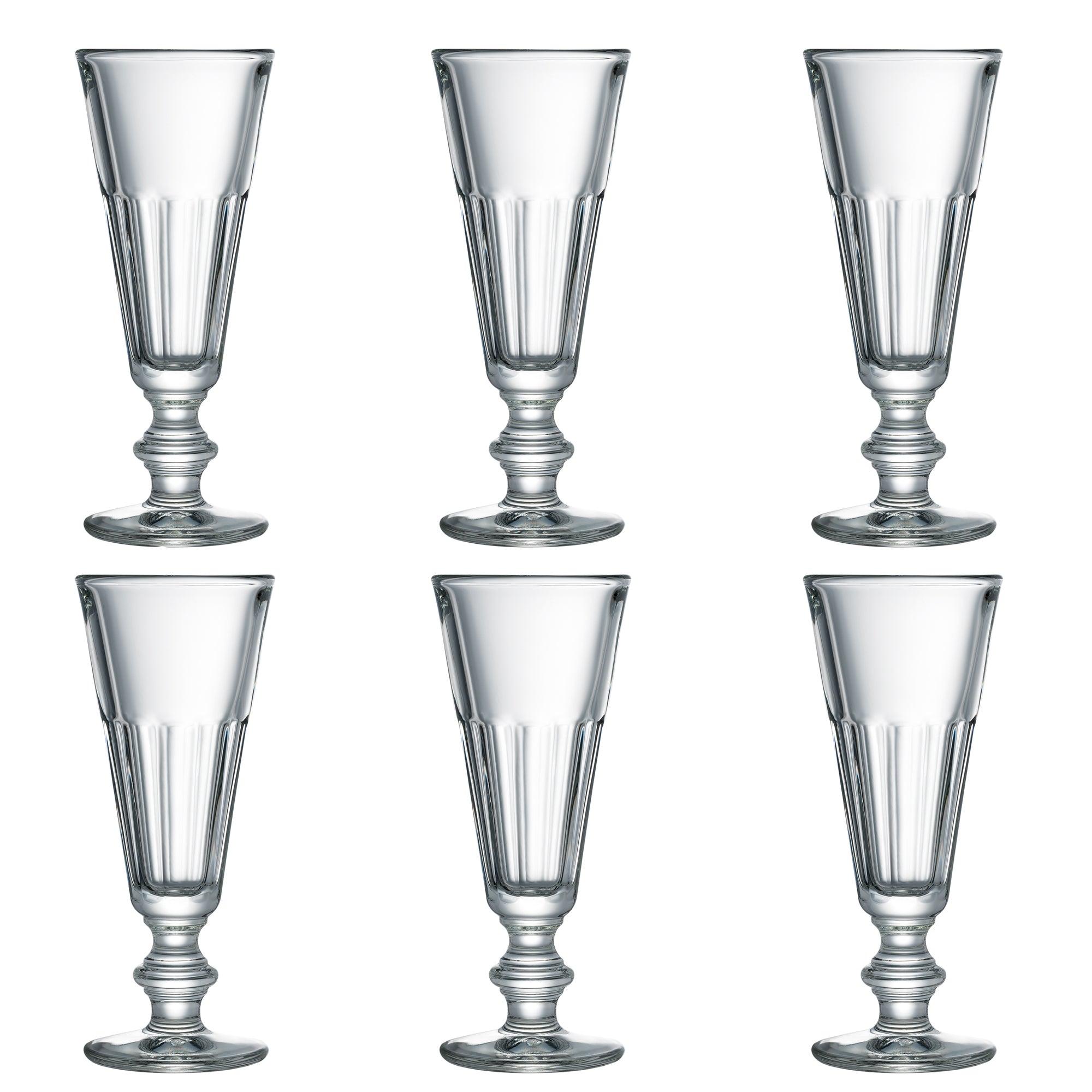 6 høje drikkeglas med smalle stængler. Glassene har et klassisk og elegant design med rillede detaljer langs siderne. De er placeret i to rækker med tre glas i hver række på en hvid baggrund